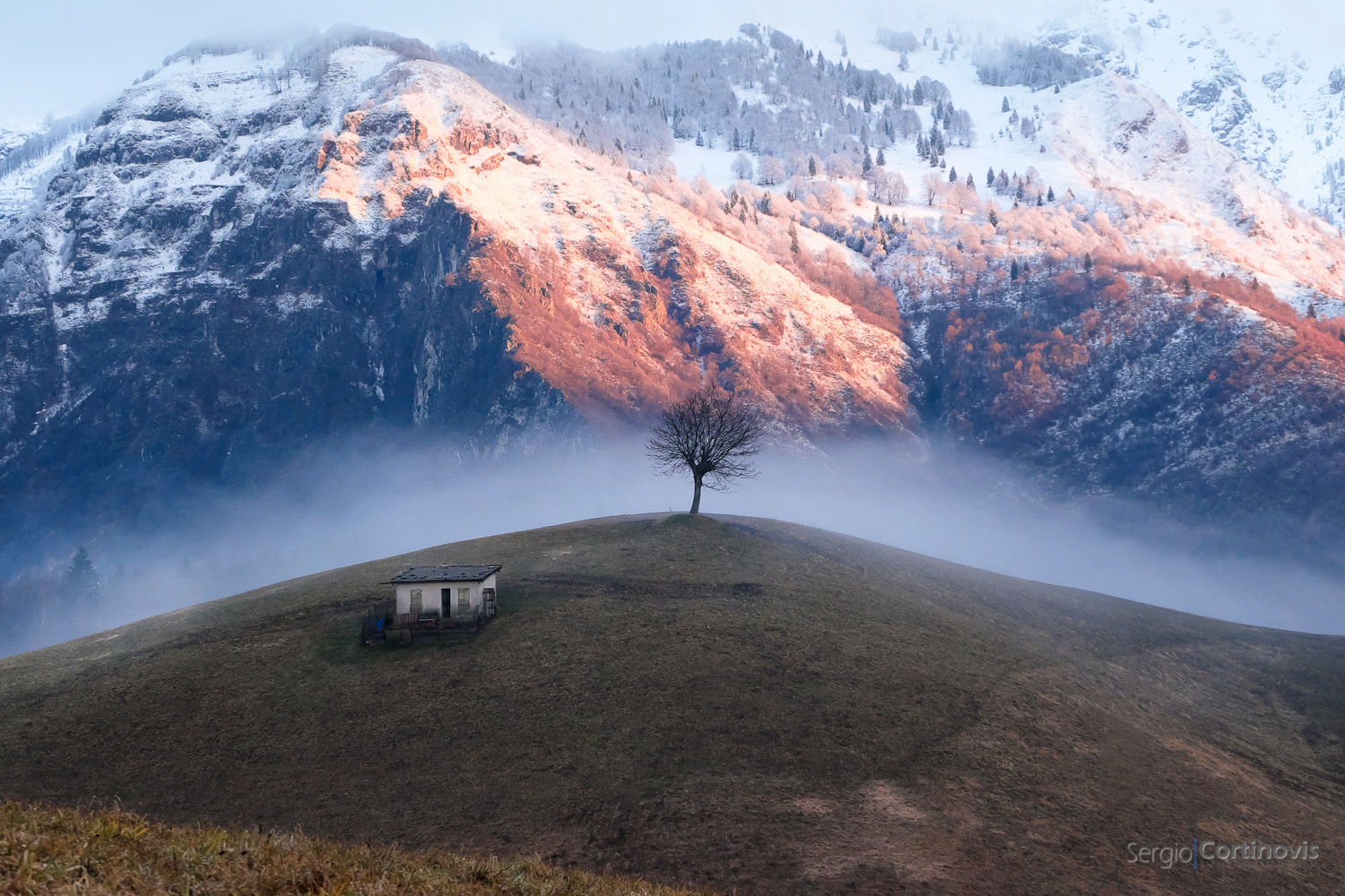 Alba a Valpiana, (comune di Serina) in Valle Serina. Una mattina invernale con sullo sfondo un panorama innevato immerso nella nebbia