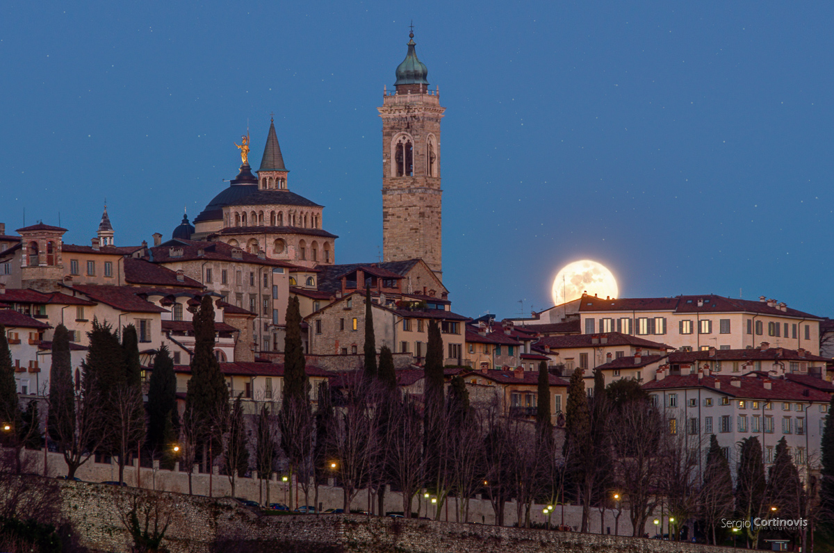 La Luna sorge dietro Città Alta (Bergamo). Accanto al nostro satellite si vede il duomo di Sant'Alessandro e la basilica di Santa Maria Maggiore