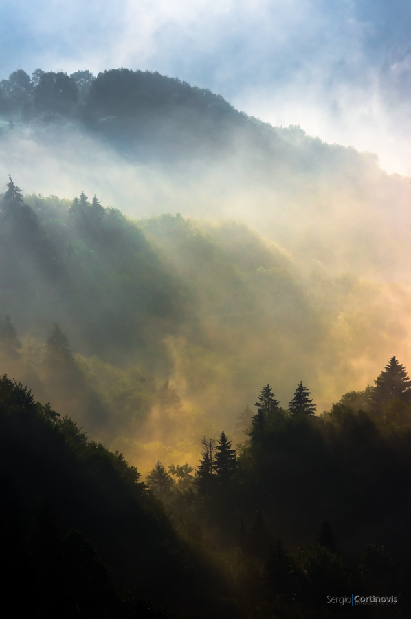 Un'immagine di ispirazione quasi romantica del Sole che incendia la nebbia radente al suolo tra le montagne di Serina