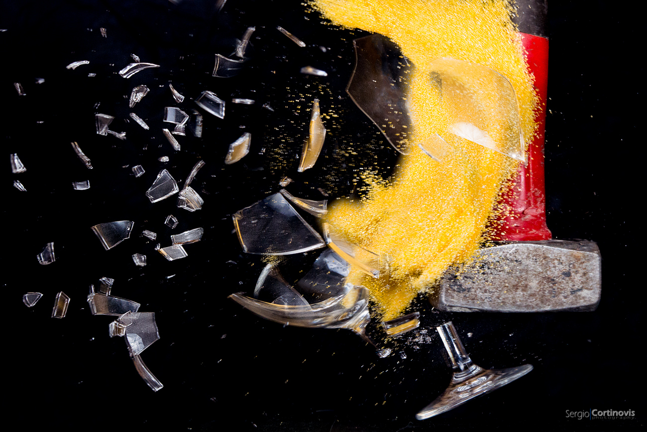 Un bicchiere pieno di farina gialla viene distrutto da un martello