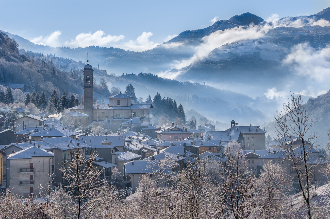 Serina con la neve, in primo piano la chiesa Parrocchiale di Santa Maria Annunciata e sullo sfondo Costa Serina, Selvino e Miragolo